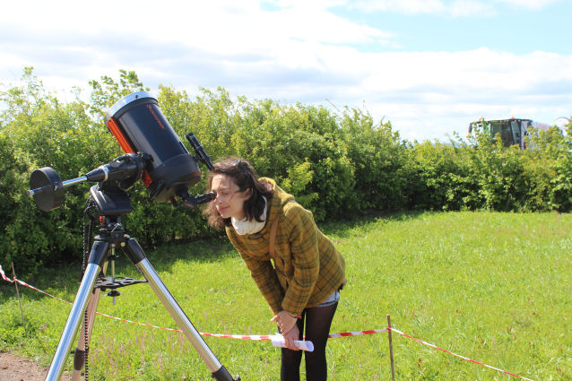 This young lady is fascinated by the sunspots visible through the telescope.